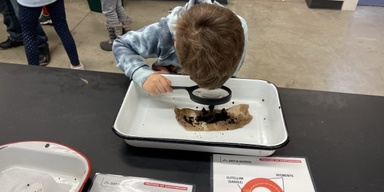 Student looking through hand lens