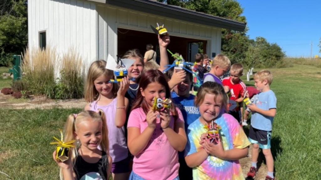 Students holding bee crafts